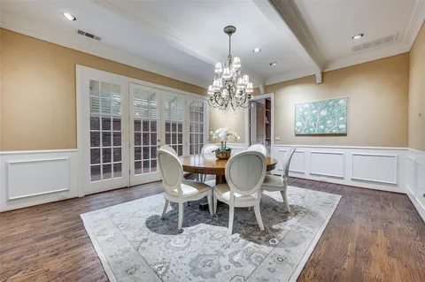 a view of a dining room with furniture a chandelier and wooden floor