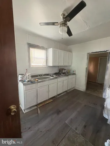 a kitchen with granite countertop a stove a sink and a refrigerator