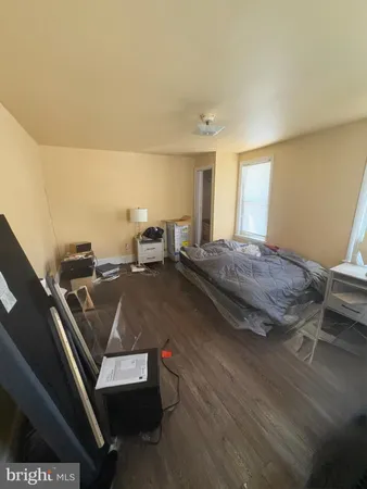 a living room with a bed and dresser