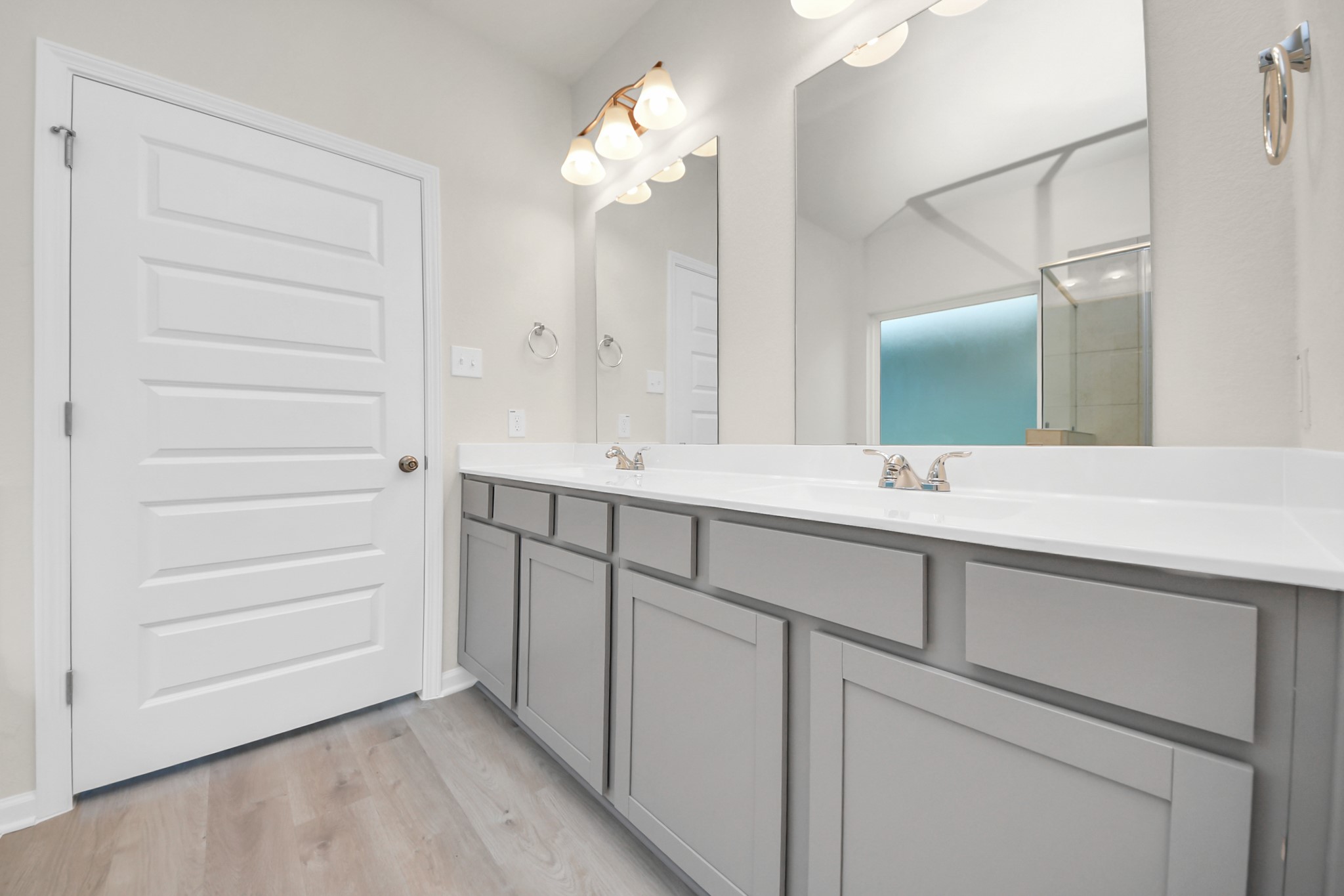 15523 Fathom Line Way Houston, TX 77053 - Photo 25 of 39 This bathroom features a spacious double vanity with modern gray cabinets, sleek fixtures, and large mirrors. The room is well-lit with overhead lighting and has a neutral color palette, creating a bright and inviting space.