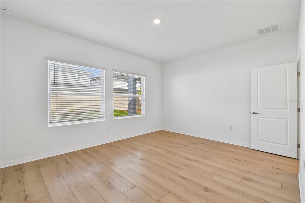 5836 Native Oak Street Mount Dora, FL 32757 - Photo 14 of 39 a view of an empty room with wooden floor and a window