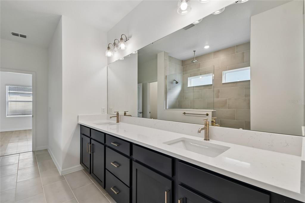 5836 Native Oak Street Mount Dora, FL 32757 - Photo 19 of 39 a bathroom with a double vanity sink a and a mirror