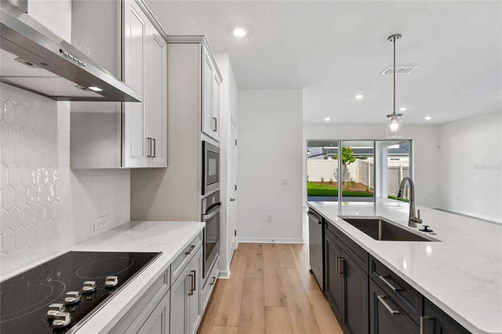 5836 Native Oak Street Mount Dora, FL 32757 - Photo 6 of 39 a kitchen with stainless steel appliances granite countertop a sink a stove and a wooden floors