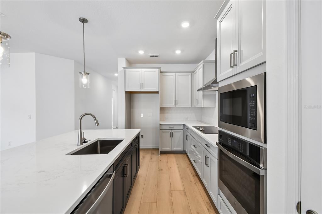 5836 Native Oak Street Mount Dora, FL 32757 - Photo 7 of 39 a kitchen with white cabinets appliances and a sink