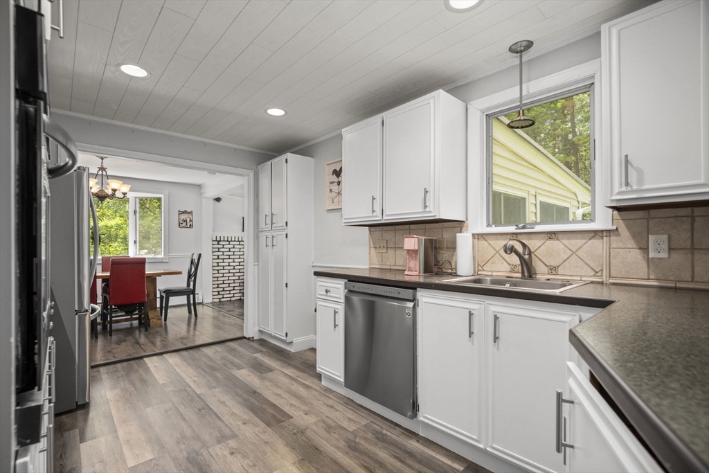 50 Haverhill Road Topsfield, MA 01983 - Photo 8 of 42 a kitchen with stainless steel appliances granite countertop a refrigerator a sink dishwasher a stove and white countertops with wooden floor