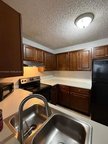 a kitchen with a refrigerator and a sink