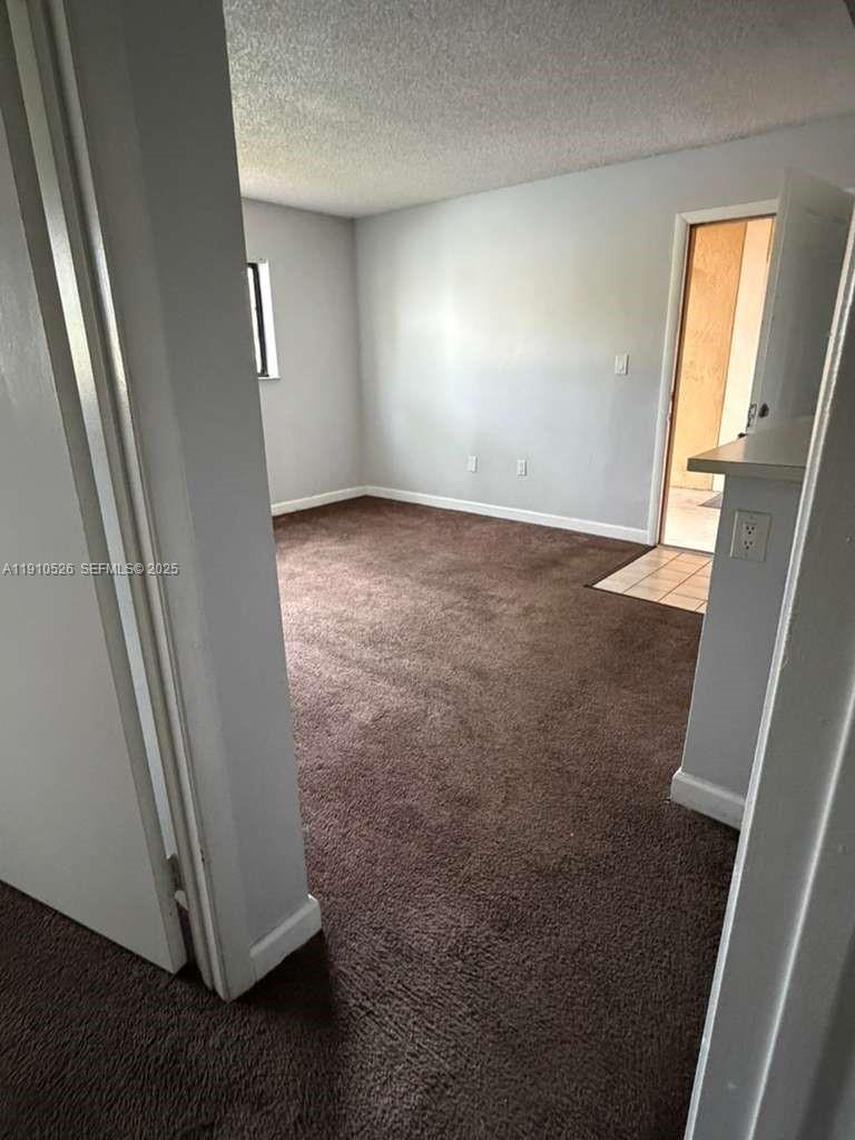 351 Palm Way, Unit 207 Pembroke Pines, FL 33025 - Photo 5 of 12 an empty room with wooden floor and windows