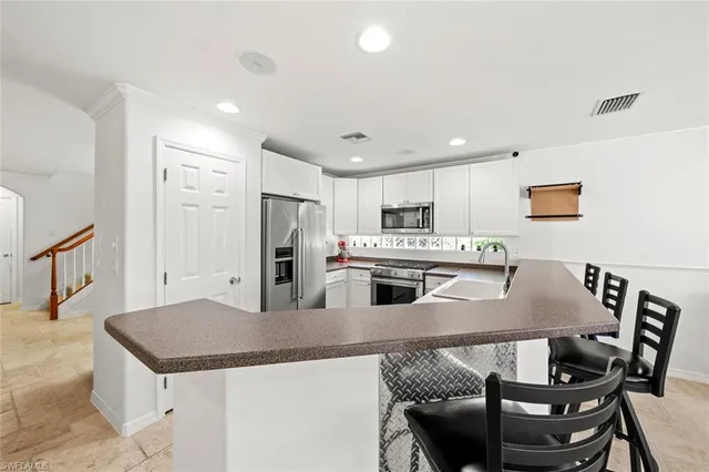 a kitchen with granite countertop a sink and white cabinets