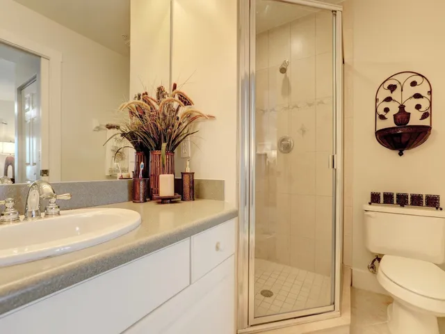 a bathroom with a granite countertop sink a toilet and a mirror