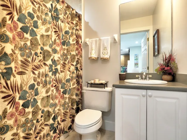 a bathroom with a granite countertop sink a toilet and a mirror