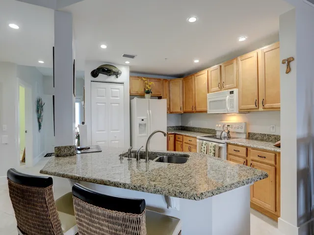 a kitchen with stainless steel appliances granite countertop a sink a stove and a refrigerator