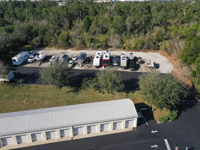 a view of a tennis ground with large trees