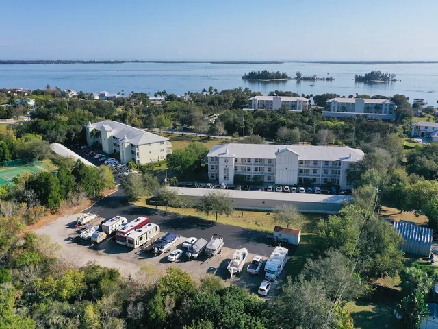 an aerial view of a house with a garden and lake view
