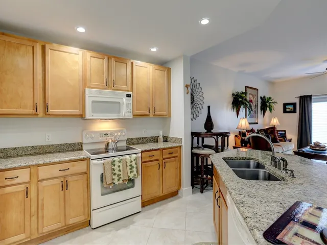 a kitchen with stainless steel appliances granite countertop a stove top oven a sink dishwasher and cabinets with wooden floor