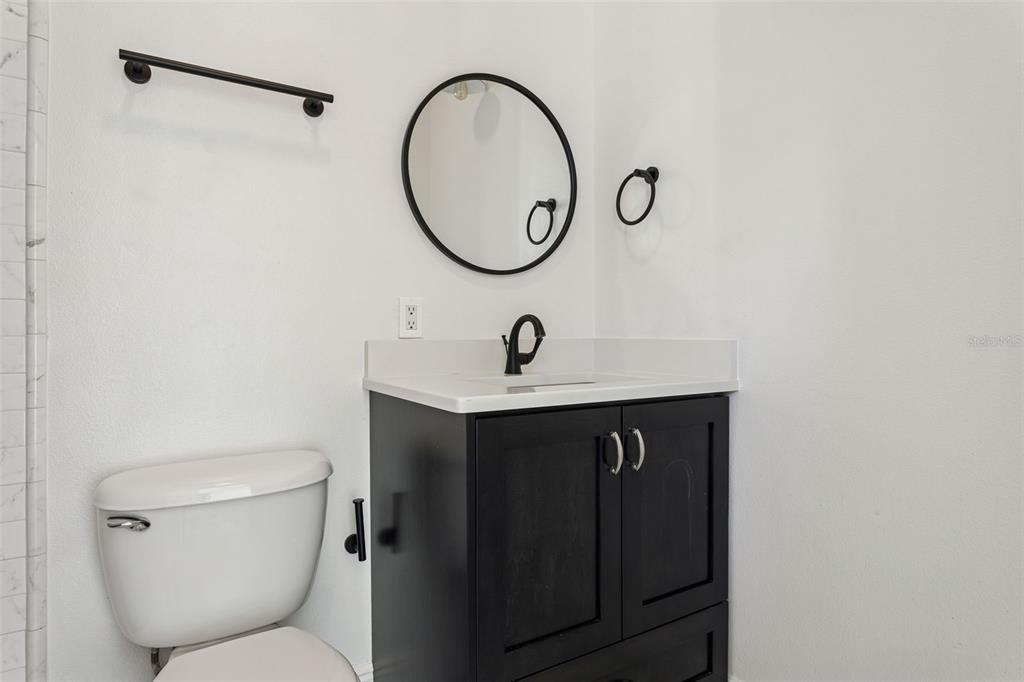 11606 Lipsey Road Tampa, FL 33618 - Photo 59 of 100 a bathroom with a toilet a sink and a mirror