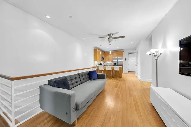 a living room with furniture and a wooden floor