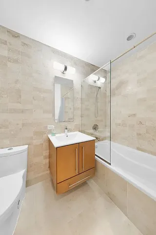 a bathroom with a tub sink mirror and a shower