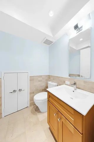 a bathroom with a sink a toilet and a mirror