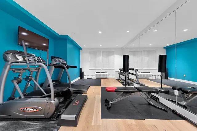 a room with gym equipment and a flat screen tv
