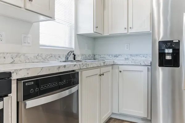 a kitchen with granite countertop white cabinets and white appliances