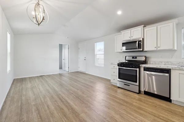 a kitchen with granite countertop a stove a microwave and cabinets