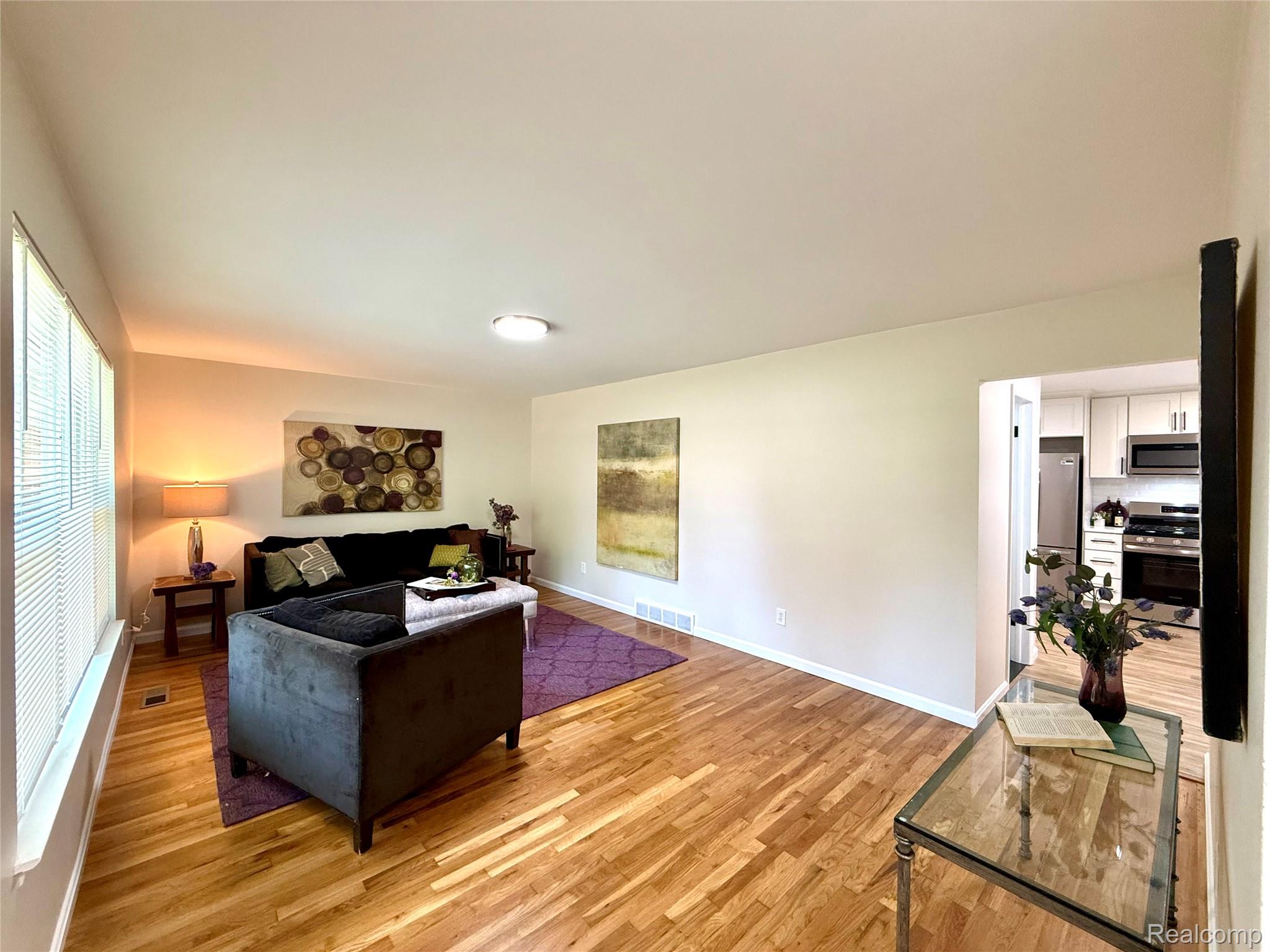 39909 Lynn Street Canton, MI 48187 - Photo 5 of 45 Bright living area featuring wood-finish flooring, ample natural light from multiple windows, and a ceiling-mounted light fixture