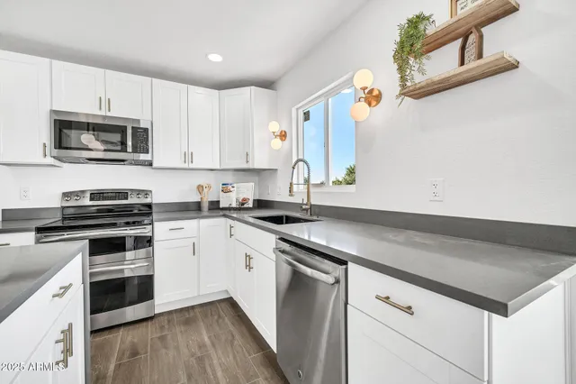 a kitchen with stainless steel appliances kitchen island wooden floors and white cabinets