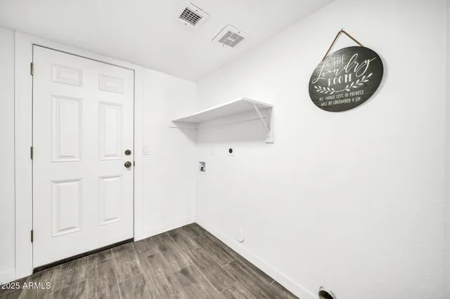 an empty room with wooden floor ceiling fan and windows