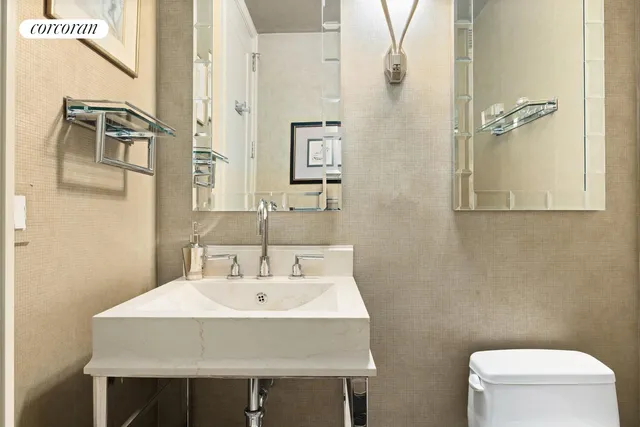 a white toilet sitting next to a bathroom sink