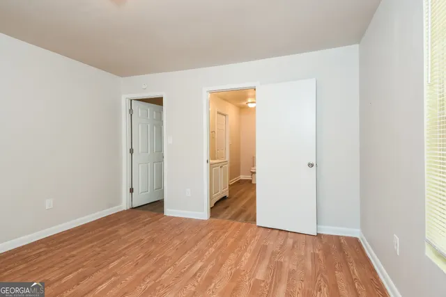 a view of a room with wooden floor and a bathroom