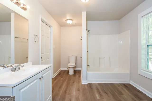 a bathroom with a sink a toilet and a large mirror