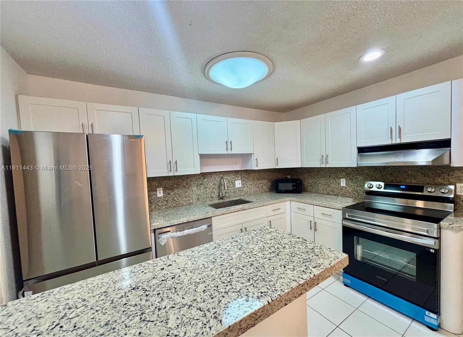 10350 Southwest 220th Street, Unit 251 Cutler Bay, FL 33190 - Photo 2 of 10 a kitchen with stainless steel appliances granite countertop a stove a refrigerator and a sink
