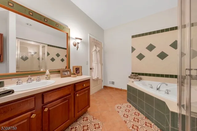 a bathroom with a tub sink and mirror