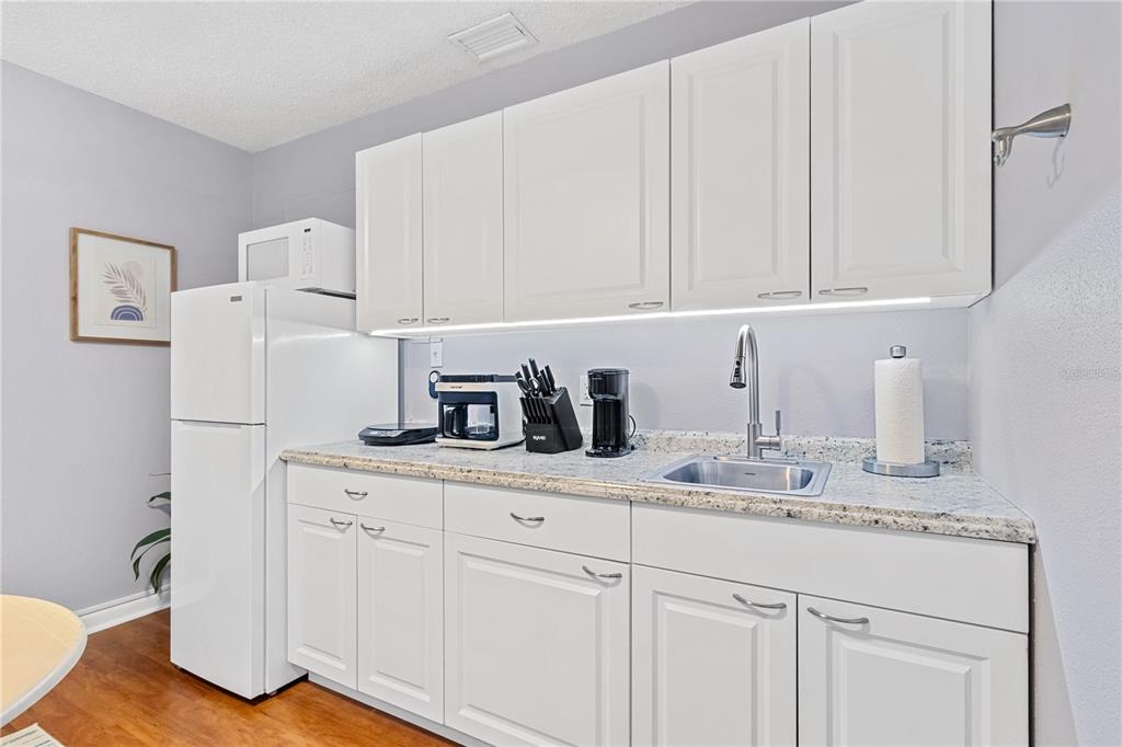 5596 100th Way North St. Petersburg, FL 33708 - Photo 30 of 67 a kitchen with granite countertop white cabinets and white appliances