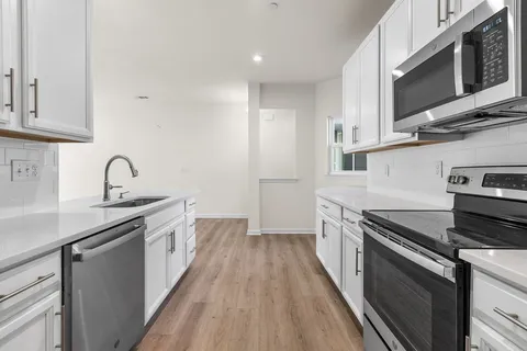 a kitchen with stainless steel appliances granite countertop a sink stove and microwave