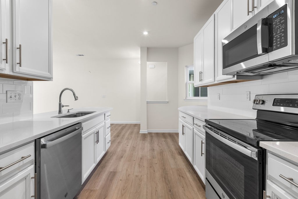 242 Marion Drive Spring Hill, TN 37174 - Photo 11 of 24 a kitchen with stainless steel appliances granite countertop a sink stove and microwave