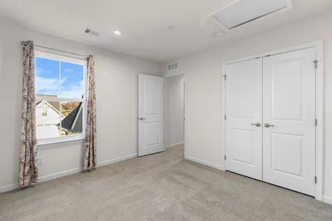 a view of an empty room and bathroom with closet