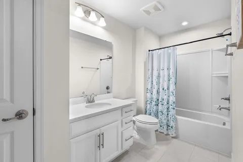 a bathroom with a double vanity sink toilet mirror and shower