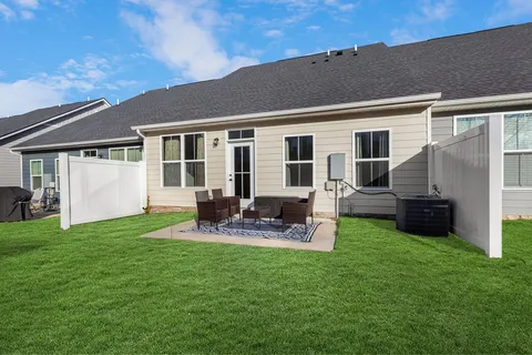 a view of a house with a yard and sitting area