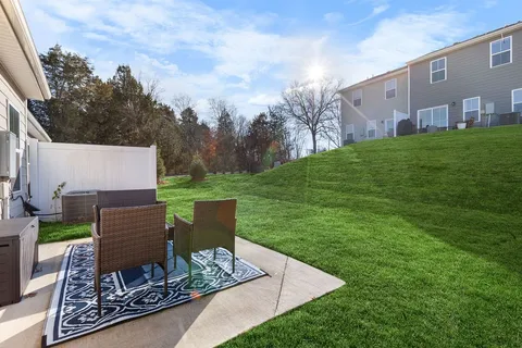 a view of a chairs and table in backyard of the house