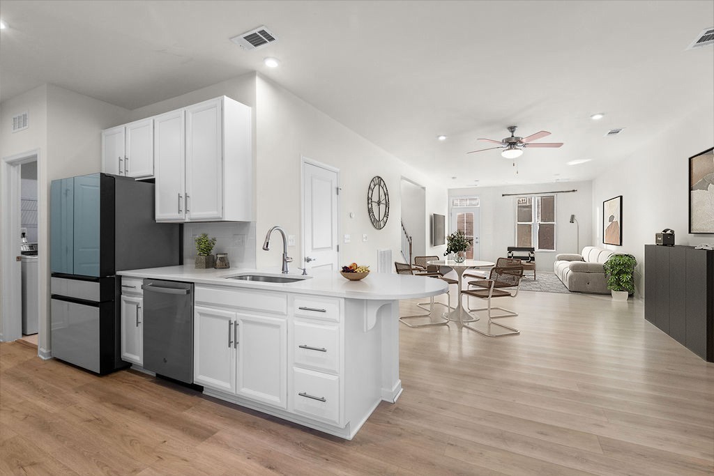 242 Marion Drive Spring Hill, TN 37174 - Photo 8 of 24 a kitchen with stainless steel appliances a refrigerator a stove a sink dishwasher and white cabinets with wooden floor