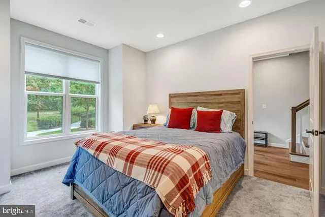 a bedroom with a bed and a lamp on dresser