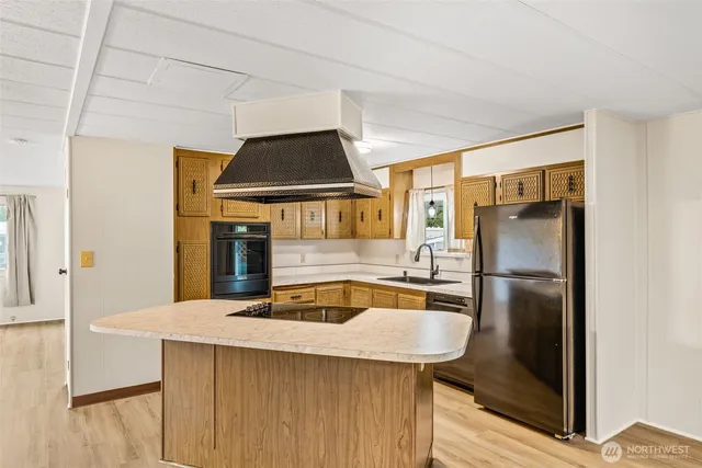 a kitchen with kitchen island a counter top space a sink and appliances