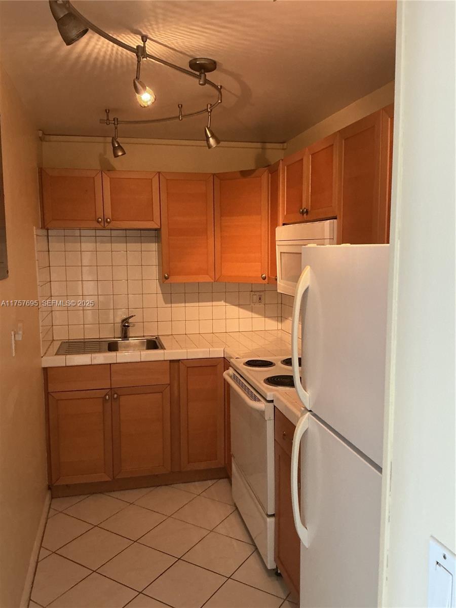 200 South Birch Road, Unit 404 Fort Lauderdale, FL 33316 - Photo 5 of 18 a kitchen with cabinets appliances and a sink