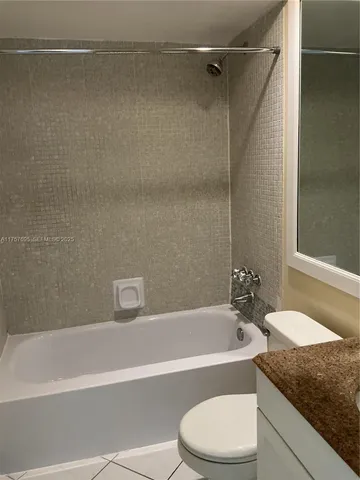 a bathroom with a granite countertop bathtub shower and toilet