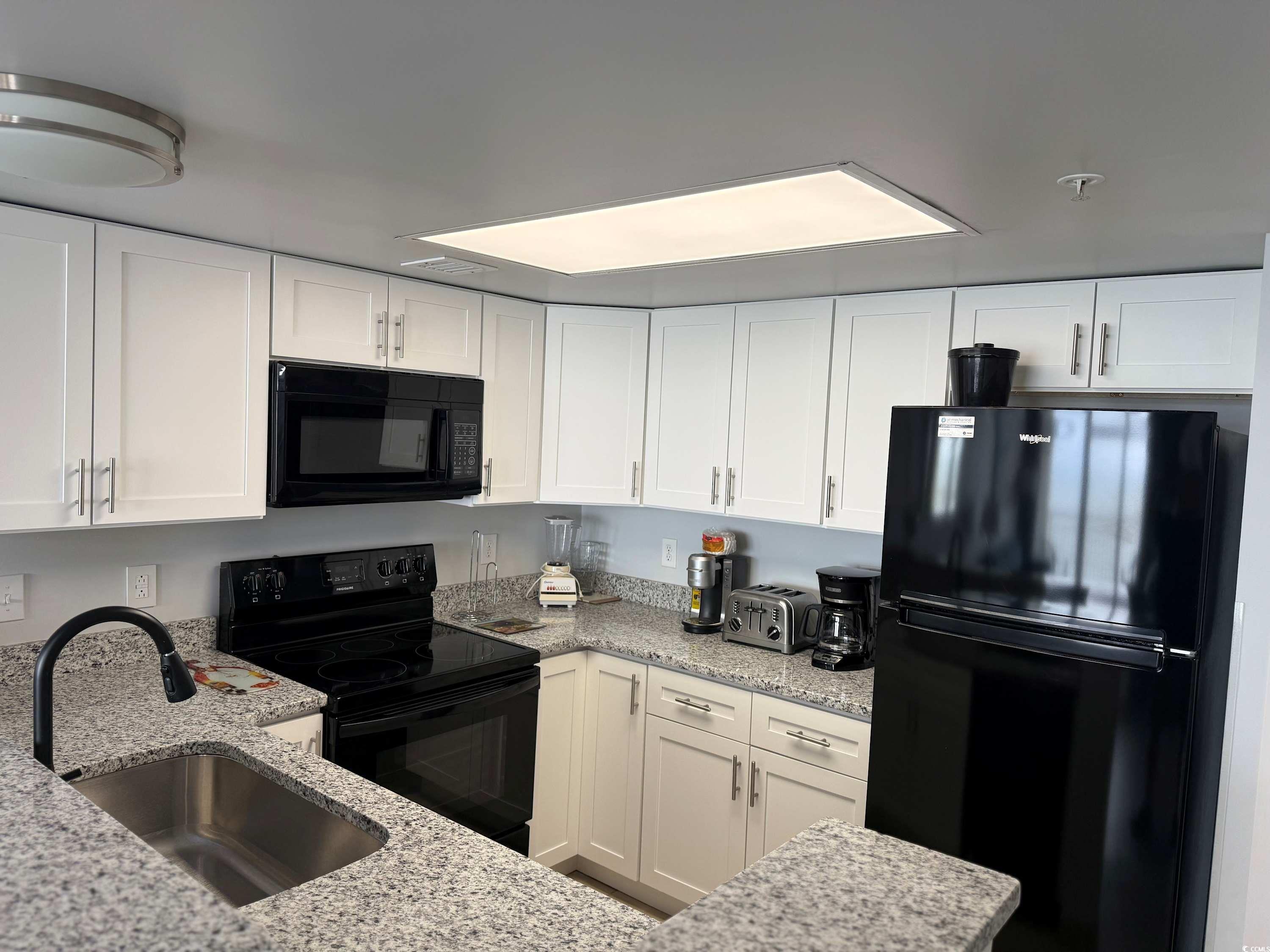 2000 North Ocean Boulevard, Unit CAMELOT 911 Myrtle Beach, SC 29577 - Photo 4 of 8 Kitchen featuring white cabinetry, black appliance