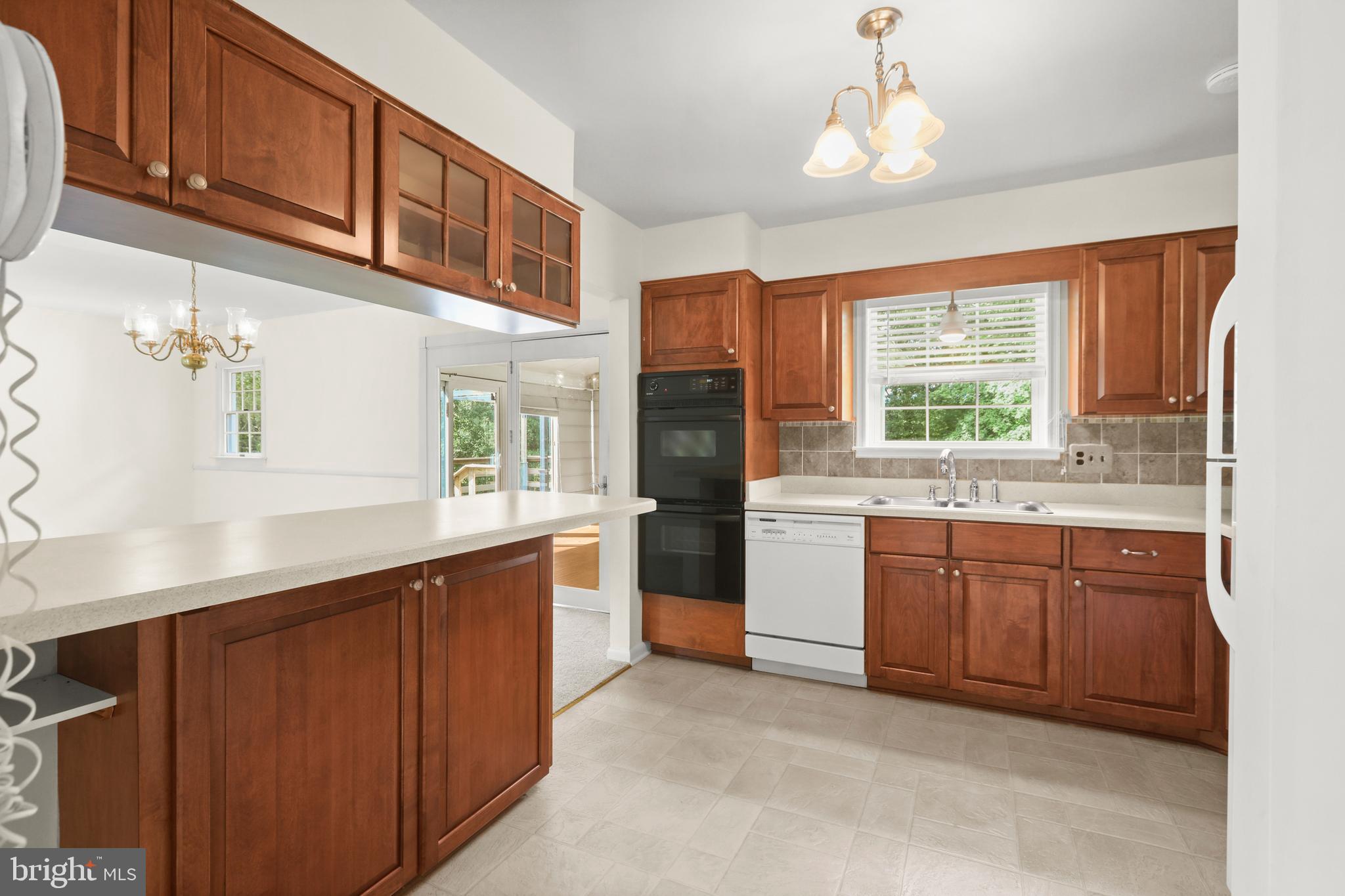 2402 Beverly Drive Joppa, MD 21085 - Photo 26 of 53 a kitchen with stainless steel appliances granite countertop a stove a sink dishwasher and a refrigerator with wooden cabinets