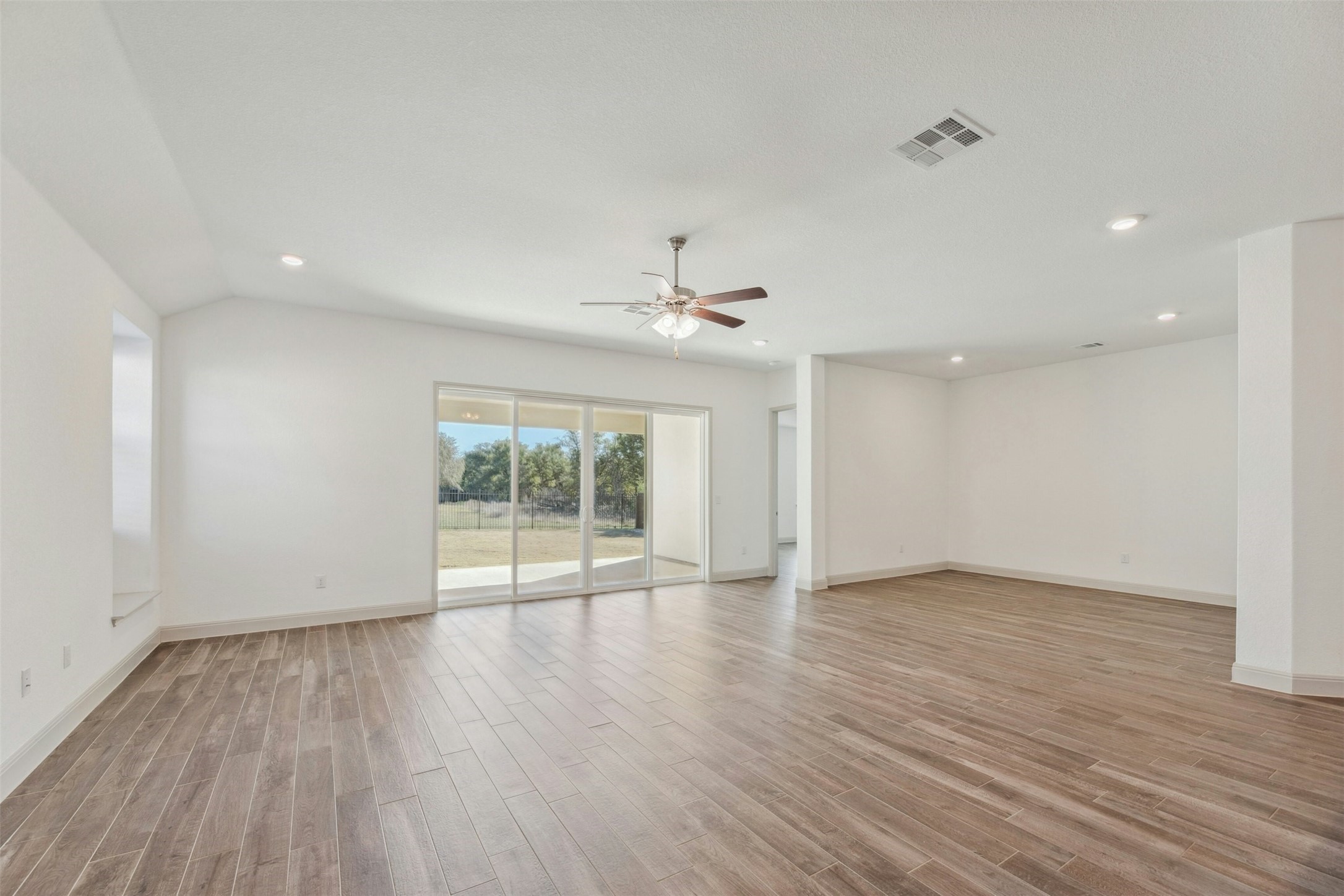 1736 Weavers Bend Georgetown, TX 78628 - Photo 11 of 40 Inside to a bright and airy interior featuring wood-look tile flooring and soaring ceilings.