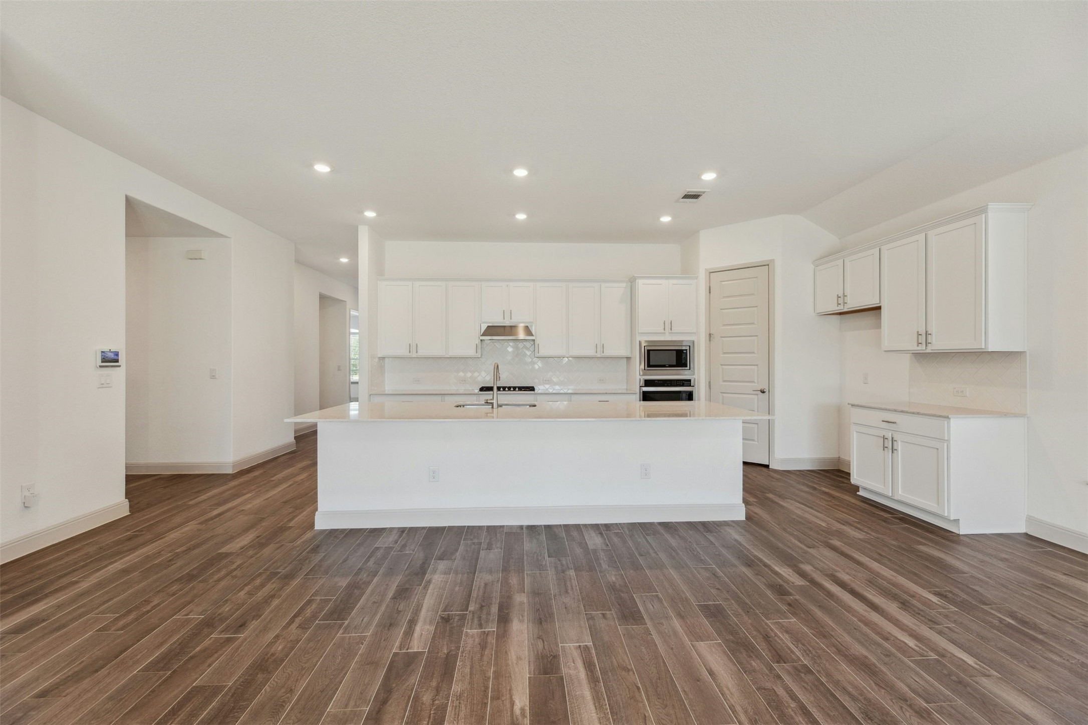 1736 Weavers Bend Georgetown, TX 78628 - Photo 8 of 40 The gourmet kitchen is a chef’s dream, showcasing contemporary finishes, premium granite countertops, and sleek stainless-steel appliances, including a built-in wall oven, microwave, gas cooktop, and dishwasher.