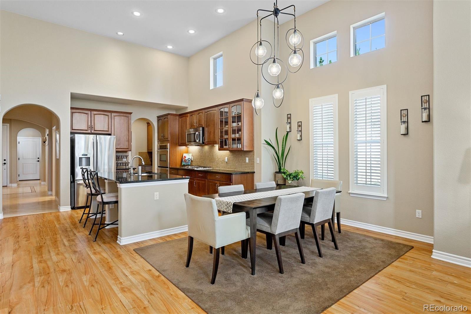 9236 Viaggio Way Highlands Ranch, CO 80126 - Photo 16 of 41 a view of a dining room with furniture window and wooden floor